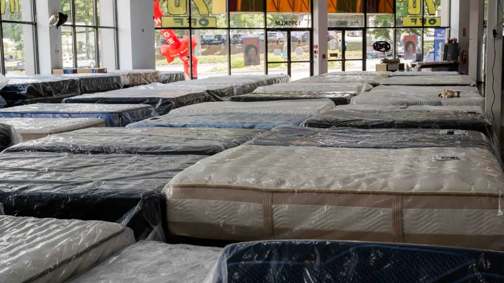 Rows of wrapped discount mattresses at Compare Deals mattress outlet