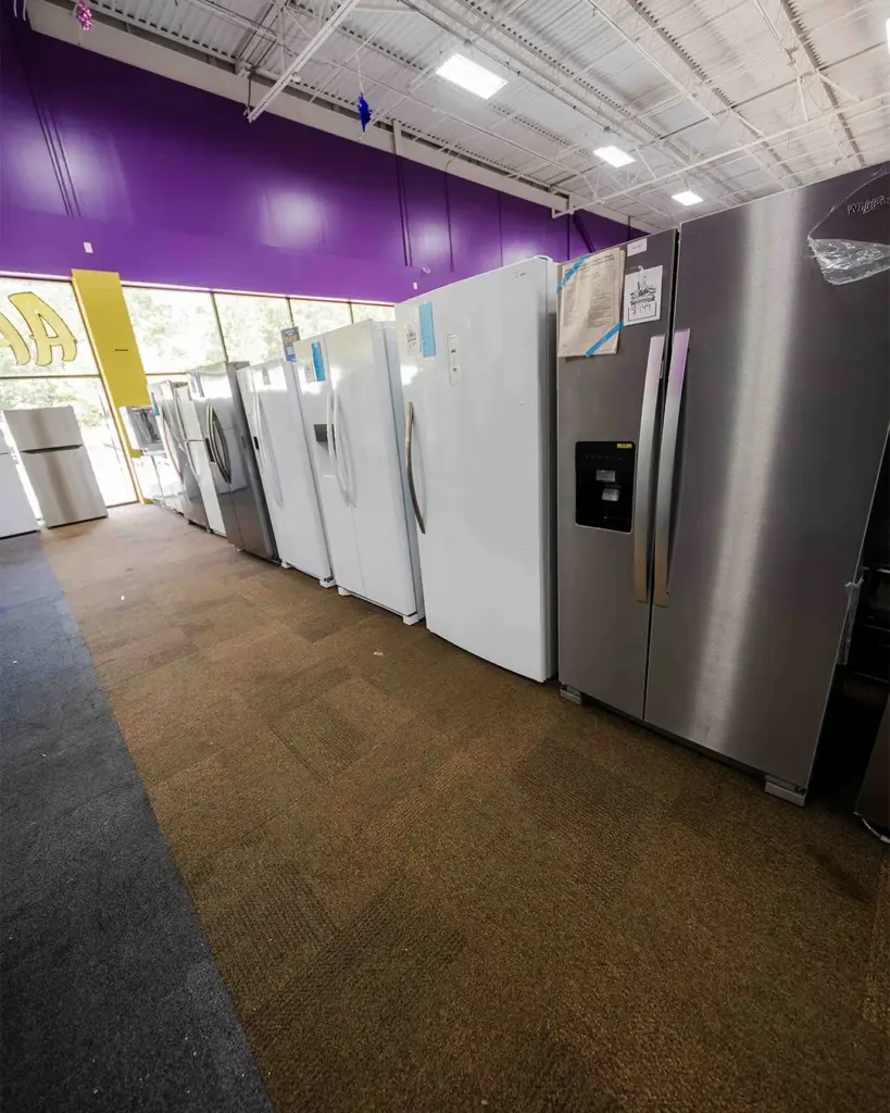 Long row of refrigerators at Compare Deals appliance outlet